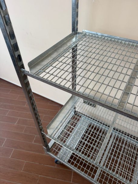 Een metalen rek met open gaasoppervlak en meerdere schappen.